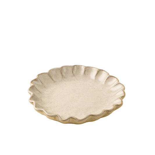 A small round ceramic plate with a scalloped, flower-like rim in a matte light gray glaze, set against a solid cream-colored background.